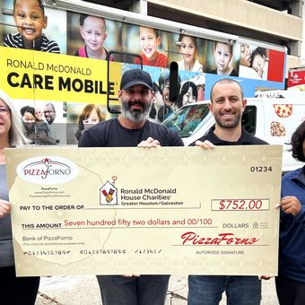 A group holding the cheque of the Pizzaforno donation of $752,000 to the Ronald McDonald House.