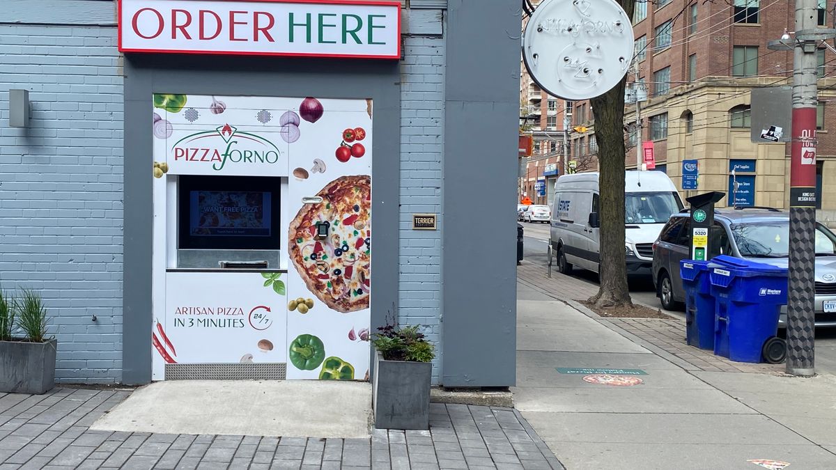 A PizzaForno automated pizza vending machine built into the side of a building on King St in Toronto.