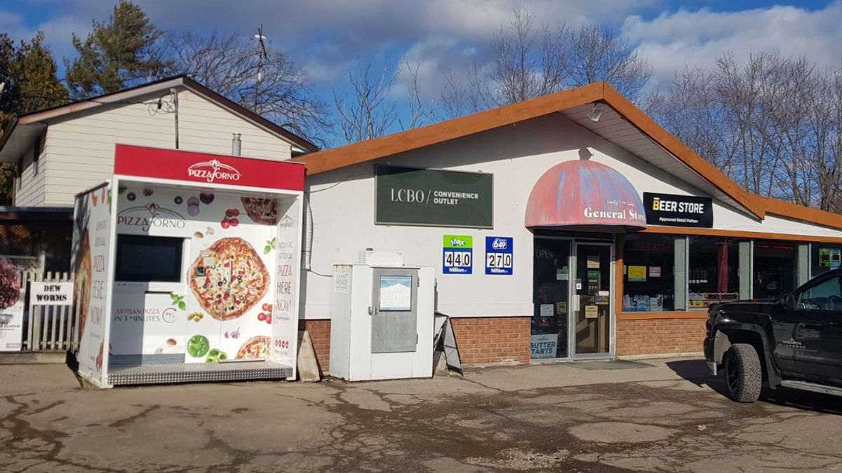 A picture of a PizzaForno pizza takeaway machine located in the parking lot beside the LCBO at Orr Lake.