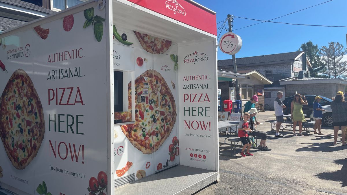 The outdoor pizza restaurant in Port Severn that has people sitting at picnic tables outside eating pizza.