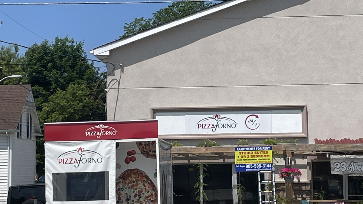 A picture taken out front of the general store in Southampton, Ontario that shows a PizzaForno automated pizzeria.